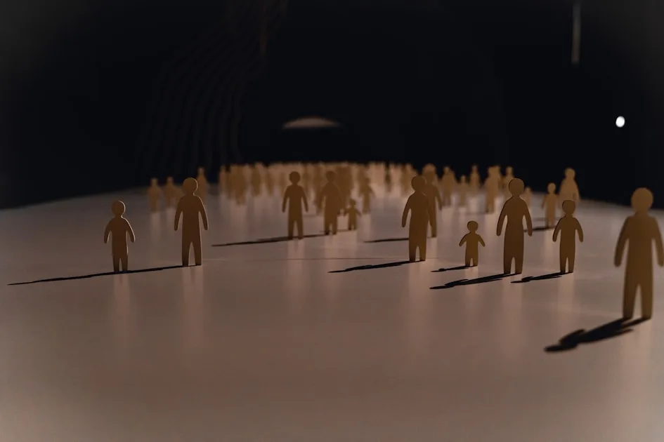 A group of small paper cutout figures on a white surface with long shadows