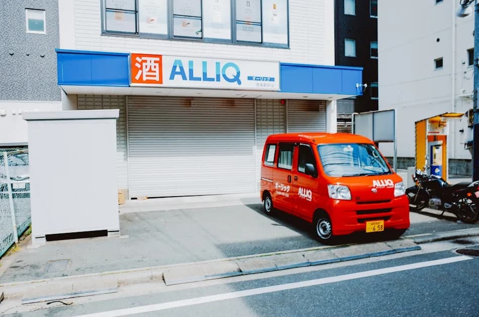Red delivery van parked outside a store.